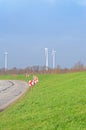 Country Road, green meadow and three wind turbines on the blue sky