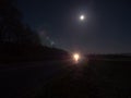 Country Road Illuminated by the Headlights of an Approaching Car Royalty Free Stock Photo