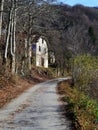 Country road and an old white house Royalty Free Stock Photo