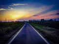 Country road with panoramic view of the sunset. Royalty Free Stock Photo