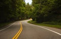 Country road in rural North America. Road with markings in the middle of the forest Royalty Free Stock Photo