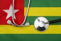 The country`s flag Togo and stethoscope. The concept of medicine