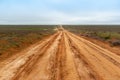 Country sandy road through the flat semidesert fields Royalty Free Stock Photo