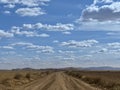 Country side view with empty road, blue sky and white cotton clouds Royalty Free Stock Photo