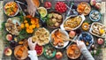 Country style. Thanksgiving table. Lots of food. Guests pour red wine into a glass. Guests are holding food with their hands over