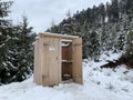 Country toilet in the winter outdoors. Outdoor toilet construction. Cabin - Toilet in the forest on the snow