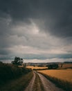 A country track heading off into the distance under a very stormy sky.