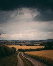 A country track heading off into the distance under a very stormy sky.