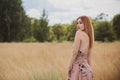 Freedom concept, elegant woman in long beige romantic dress at the field