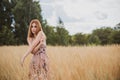 Freedom concept, elegant woman in long beige romantic dress at the field