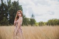 Freedom concept, elegant woman in long beige romantic dress at the field