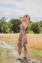 Freedom concept, elegant woman in long beige romantic dress at the field