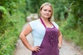 Country woman in apron staning hands on hips on the road