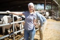 country woman posing with glass of milk at cowfarm