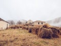 Countryside area overgrown with dry grass with haystacks and old abandoned houses. The highlands of the Caucasus covered Royalty Free Stock Photo