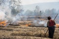 Countryside field with fire made with dry rice straw with woman farmer working on field in Gia Lai, central highland of Vietnam