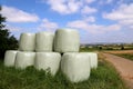 Countryside field with hay bale wrapped in plastic