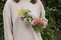 A countryside girl in a white blouse holding flowers from field in her hand. Royalty Free Stock Photo