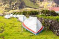 Countryside grass street with a row of drying overturned boats. British Governor flag flying. Edinburgh of the Seven Seas, Tristan