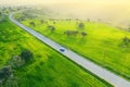 Countryside green landscape with a car driving down an asphalt road and a car, view from above Royalty Free Stock Photo