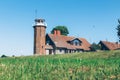 Countryside house on green lawn with blue sky