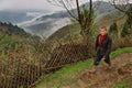 Countryside mountainous China, farmer, walks along a wicker fence. Royalty Free Stock Photo