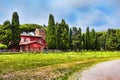 Countryside panorama with ancient farmhouse surrounded by lawn