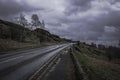 Countryside road with stone walls aside in Peak District National Park,Derbyshire,Uk.Cloudy sky and scenic panorama in background Royalty Free Stock Photo