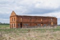 countryside rural landscape. an old, ruined, abandoned red brick building stands on the field. Royalty Free Stock Photo