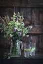 Countryside scene with wildflowers in a vase and glasses with water