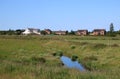 Countryside view, stream, brick houses, meadows Royalty Free Stock Photo