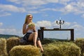 Countryside woman in boho style with hay stack. Beautiful young woman in fashion dress outdoor. Sexy and sensual female