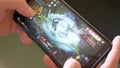 A man holds a smartphone and plays MMORPG Black Desert Online, illustrative editorial. Video