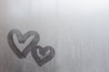 Couple of abstract blurred love heart symbol drawn by hand on the wet window glass with sunlight background. Template for Valentin