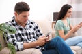 Couple addicted to smartphones ignoring each other at home Royalty Free Stock Photo