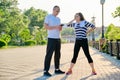 Couple of adult people resting talking after sports exercises, jogging in the park Royalty Free Stock Photo