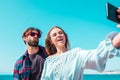 Couple of adults taking a selfie doing stupid and funny expressions with their faces - happy two people having fun taking photos Royalty Free Stock Photo