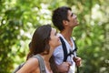 Couple, adventure and backpack for hiking in rainforest with smile for thinking, holiday or search in summer. Man, woman Royalty Free Stock Photo