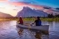 Couple adventurous friends are canoeing in a lake surrounded by the Canadian Mountains. Royalty Free Stock Photo