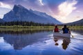 Couple adventurous friends are canoeing in a lake surrounded by the Canadian Mountains. Royalty Free Stock Photo