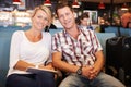 Couple In Airport Departure Lounge Waiting To Go On Vacation Royalty Free Stock Photo