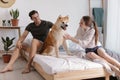 Couple and Akita Inu dog in bedroom
