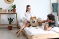 Couple and Akita Inu dog in bedroom with houseplants