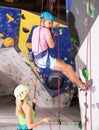 Couple of alpinist practicing in pair indoor rock-climbing Royalty Free Stock Photo