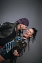 Couple of alternate and smiling man and woman pose embraced in study shot on gray background