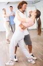 Couple of amateur dancers dancing in pairs during group class in studio Royalty Free Stock Photo
