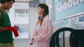 Couple argue laundry room doing daily chores. Angry upset girl throwing red sock Royalty Free Stock Photo