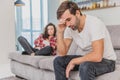 Couple argue. The wife shouted to her desperate husband, sitting on the couch in the living room at home. A man does not