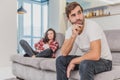 Couple argue. The wife shouted to her desperate husband, sitting on the couch in the living room at home. A man does not