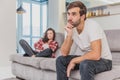 Couple argue. The wife shouted to her desperate husband, sitting on the couch in the living room at home. A man does not